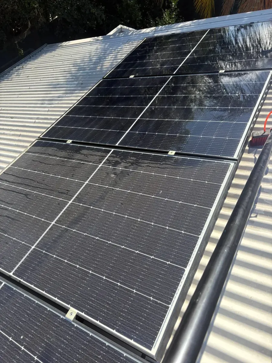 Solar panel cleaning by Shepp City Carpet Cleaning with brush and hose on residential roof in Shepparton