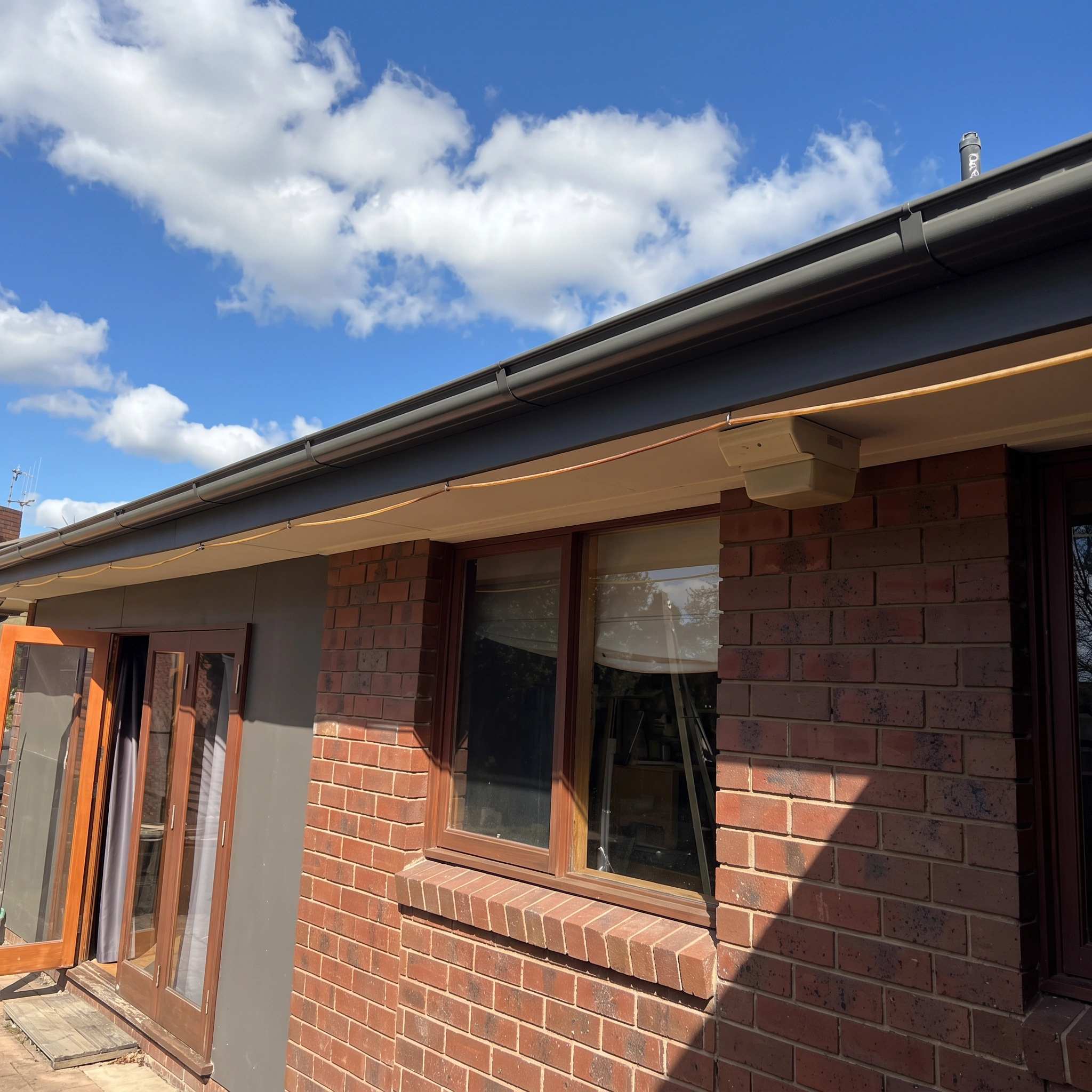 Clean dark grey gutters and fascia on a brick home in Shepparton